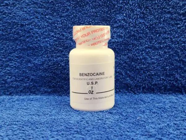 A bottle of benadryl sitting on a blue towel.