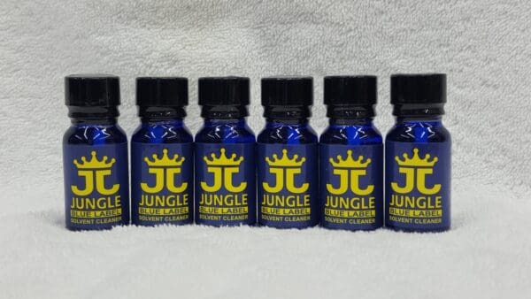 Six bottles of Jungle Juice Blue arranged in a row on a white textured background.