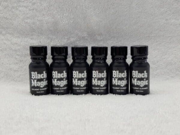Five black magic bottles on a white background.