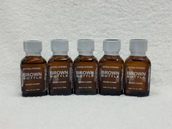 A group of brown bottles sitting on top of a white wall.