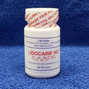 A bottle of lidocaine hcl on a blue towel.