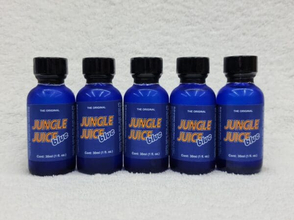 Five blue bottles labeled "Jungle Juice Blue" arranged side by side on a white textured background.