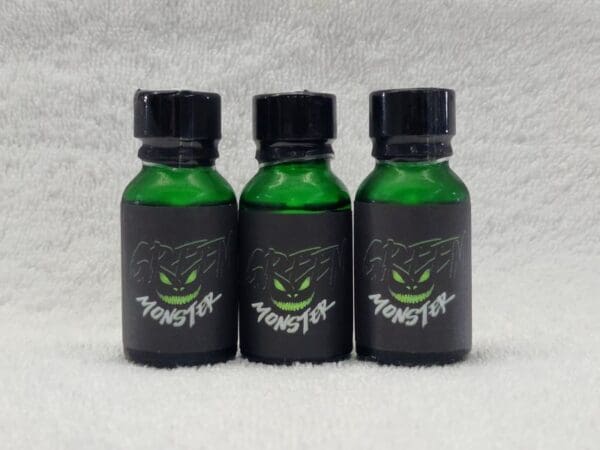 Three bottles of green liquid with a green face on them.