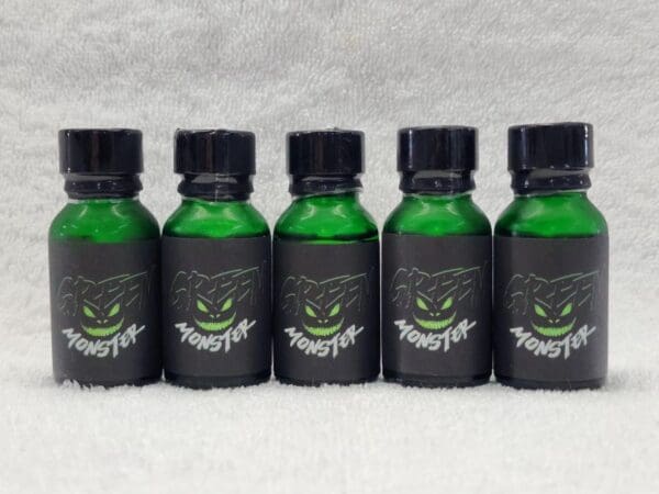 Five bottles of green liquid with a monster face on them.