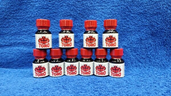 Nine bottles of Toro seasoning arranged in three rows on a blue textured background.