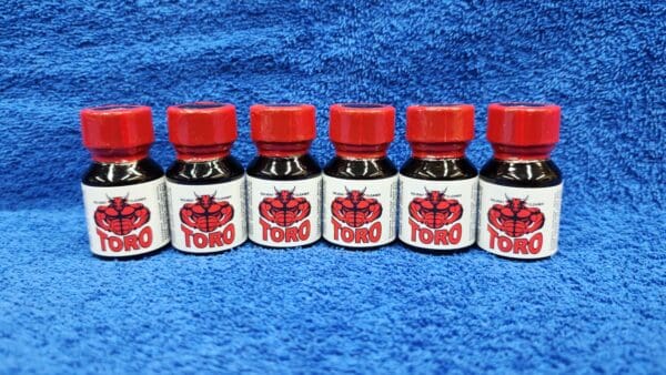 Six bottles of Toro ink with red caps and labels featuring a red rose, aligned in a row on a blue textured background.