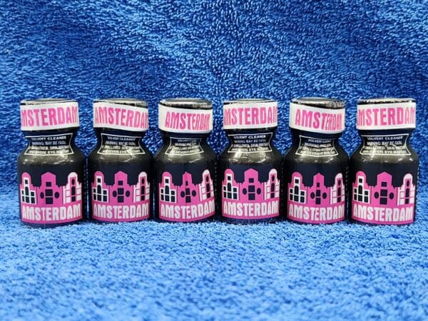 A row of pink and black bottles on blue carpet.