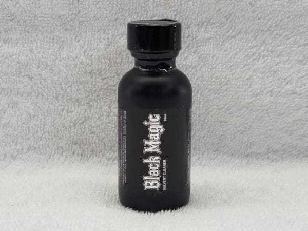 A bottle of black magic is sitting on the floor.
