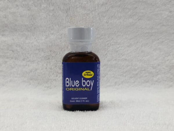 A bottle of blue boy is sitting on the floor.