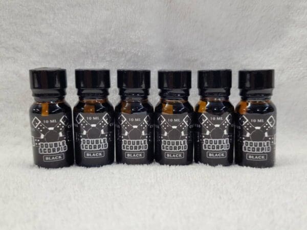 Five bottles of black beard oil on a white background.