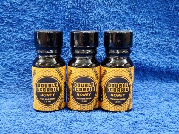 Three bottles of beeswax on a blue towel.