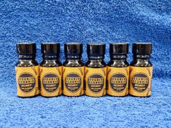 Five bottles of beard oil on a blue background.