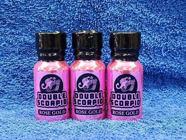 Three bottles of pink liquid on a blue towel.