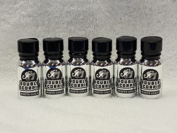 A group of six bottles with black caps on them.