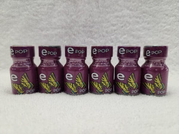 Five bottles of Ecstasy Pop e-liquid sitting on a white surface.