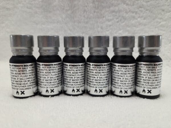 Five bottles of black liquid with an x in the middle.