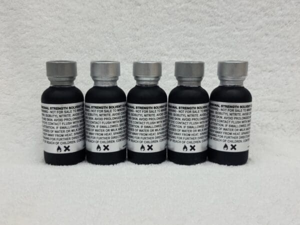 A group of five bottles of black liquid.