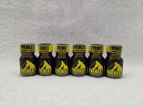 A group of bottles with yellow labels on them.