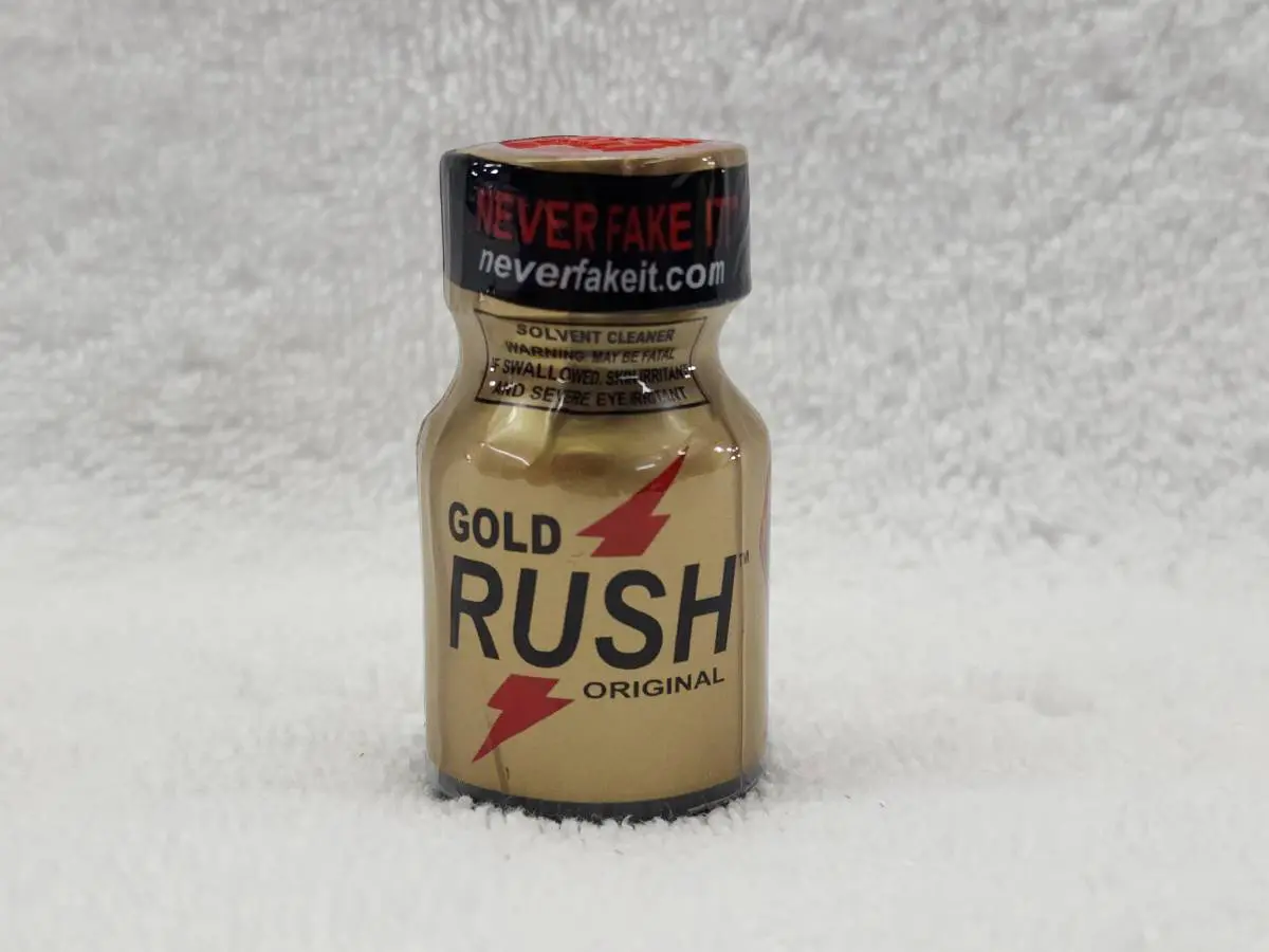 A bottle of gold rush poppers on the floor