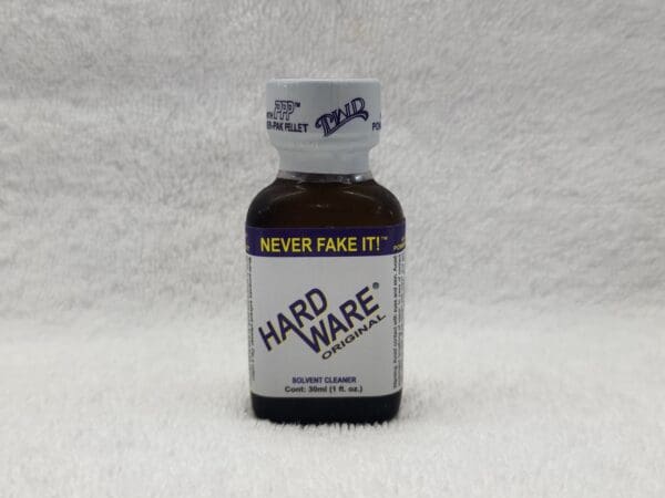 A bottle of hard ware is sitting on the floor.