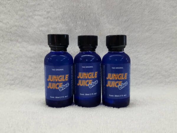 Three bottles of blue liquid sitting on top of a white surface.