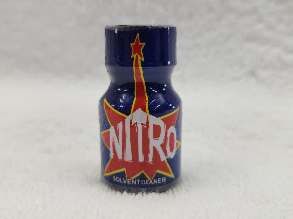 A blue bottle of nitro poppers on top of a white blanket.