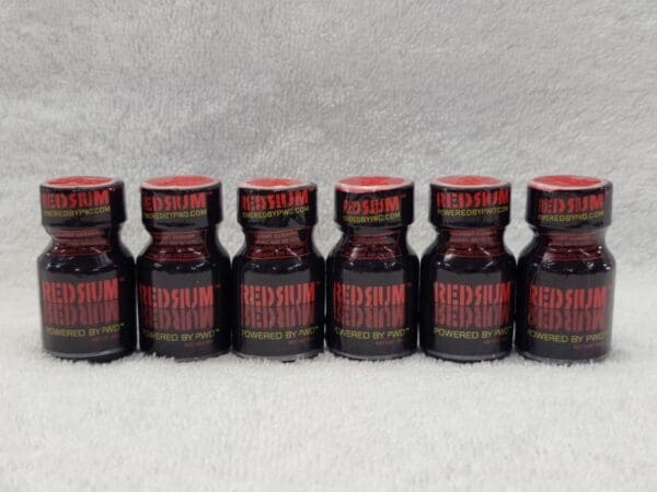 A row of red bottles sitting on top of a table.