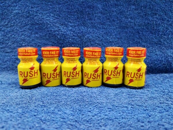 A row of yellow rush poppers sitting on top of a blue carpet.