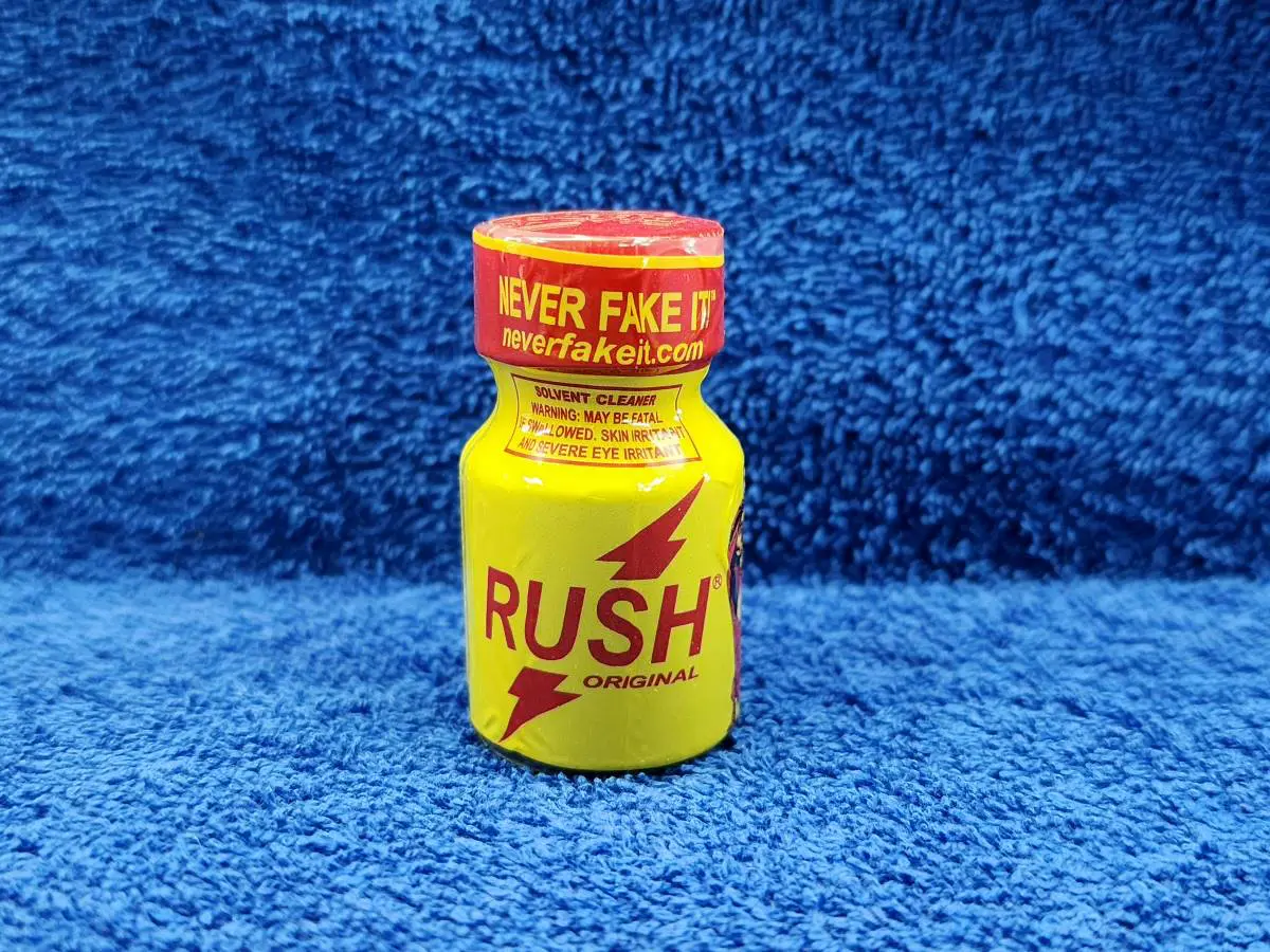 A yellow bottle of rush is sitting on the floor.
