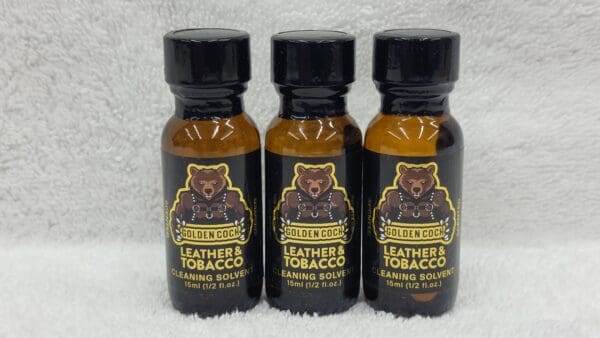 Three bottles of Golden Cock Leather & Tobacco cleaning solvent lined up against a white background.