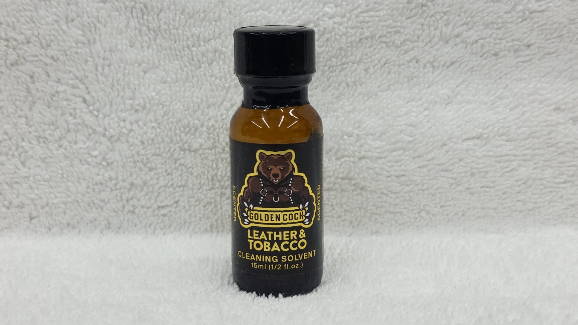 A bottle of Golden Cock Leather & Tobacco cleaning solvent on a white towel, 15 ml size.