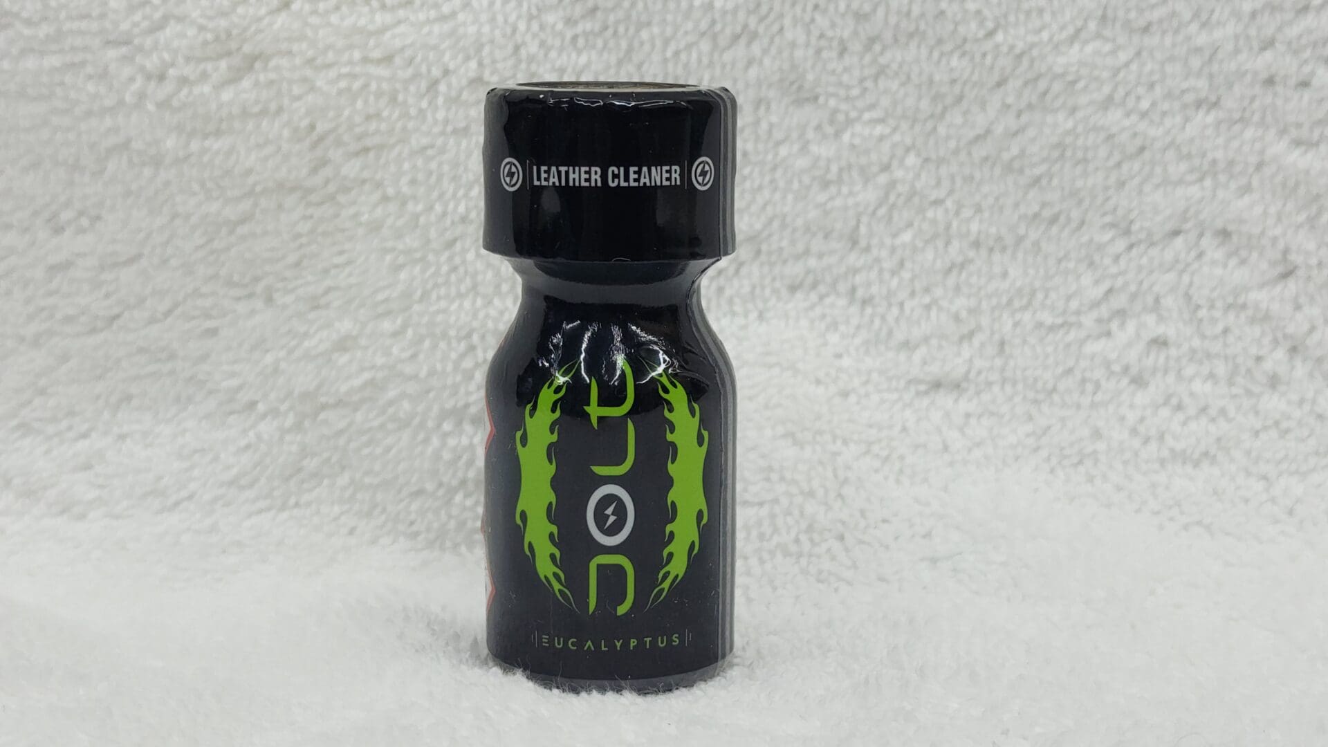 A bottle of Jolt Coconut labeled "eucalyptus leather cleaner" with a black cap and green flame designs on a white textured background.