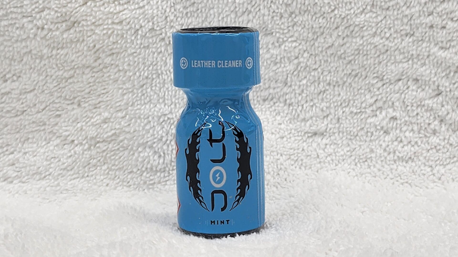 A blue bottle of Jolt Coconut leather cleaner labeled "mint" on a white textured surface.
